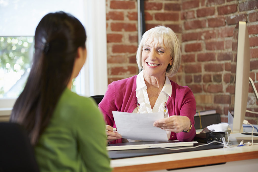 Happy Smiling Businesswoman Interviewing Female Job Applicant In Office